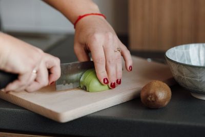 mujer cortando kiwi nutricion, alimentacion-autocuidado